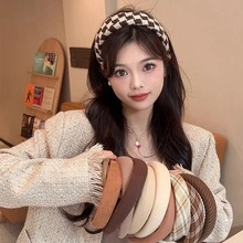 Classic checkered fabric headband worn by a model in a cozy vintage cafe setting