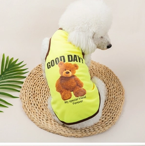 Close-up of breathable yellow mesh dog vest with teddy bear print on a white puppy