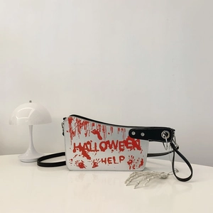Detail of Halloween cleaver bag with red blood splatter and skull hand pendant charm