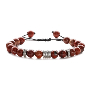 Detailed shot of reddish-brown natural agate beads with silver metal spacers on a braided cord