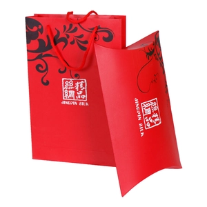 Detail of red paper gift bag and pillow box with classic silk print logo