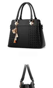 Detail view of black faux leather handbag featuring woven texture and gold flower tassel