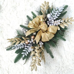 Close-up of Christmas stair garland with gold bow and glitter ornaments on fur rug