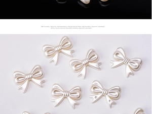 Detailed macro view of pearlescent cream white resin bow charms for DIY jewelry making