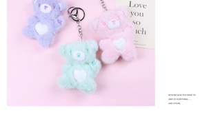 Close-up of cute plush heart bears in purple, light green, and pink with metal chains