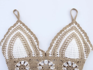 Detailed macro view of beige and white crochet knit texture on a halter camisole top