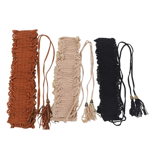 Close-up of three waist belts with lace trim and tassel ties in brown, beige and black