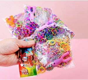 Close-up of four packs containing 600 colorful DIY loom bands and tools for kids bracelets