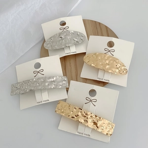 Detailed view of 4 pieces of hammered metal geometric hair clips in gold and silver finish