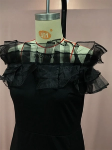 Detail eines eleganten schulterfreien Rüschen-Ausschnitts an einem schwarzen Abendkleid
