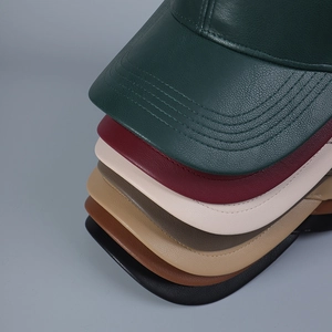 Detailed macro view of multi-color faux leather baseball cap brims with pebble texture