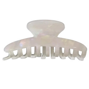 Detail shot of pearlescent white acetate hair claw clip with glossy iridescent finish