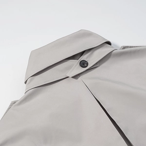 Detailed back view of grey trench coat collar with fine stitching and black button accents