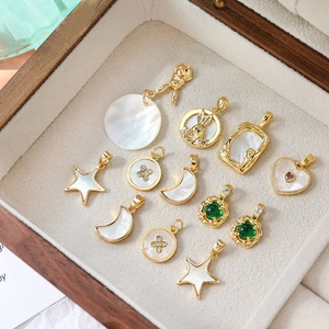 Detail shot of 12 gold plated shell charms in various shapes for DIY jewelry making