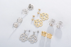 Flat lay of multiple hollow rose and heart stud earrings in gold and silver steel finish