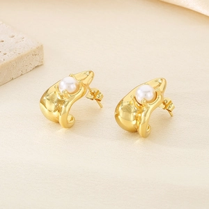 Détail des boucles d'oreilles fleur plaquées or 18k avec perles blanches sur soie