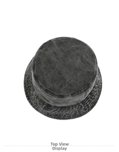 Vista dall'alto della texture denim lavato e della tesa cucita del cappello a secchiello grigio