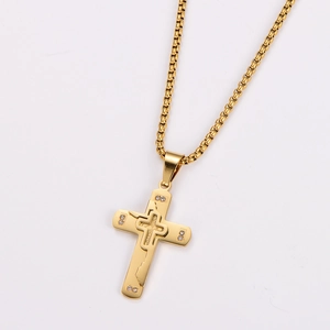 Close-up of gold double-layer necklace featuring cross pendant and small inlaid diamonds