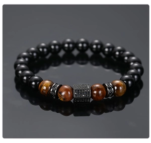 Detailed view of men's matte black beads and tiger eye stone bracelet with pavé hex charm