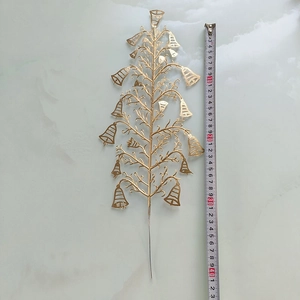 Détail de tiges de cloches dorées au design évidé sur marbre avec ruban à mesurer