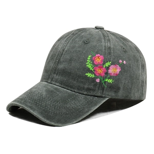 Detailed embroidery of pink flowers on a dark gray washed cotton baseball cap