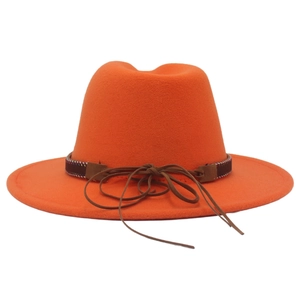 Detail of bright orange wool fedora hat featuring ethnic woven band and leather cord tie