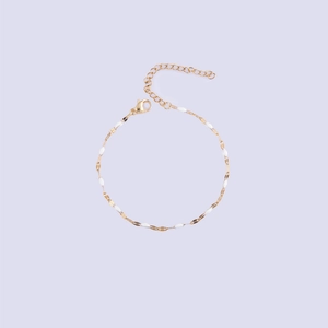 Polished gold lip chain with white enamel oval beads and lobster clasp closure detail