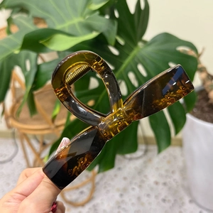 Close-up of tortoise shell resin hair claw clip with glossy finish and metal spring