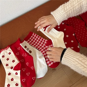 Detail of red and white patterned knit socks featuring hearts, plaid and polka dots