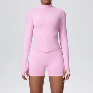 Détail ensemble de yoga rose avec veste zippée à passe-pouces et short de sport moulant