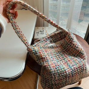 Close-up of colorful woven knit shoulder bag with metal magnetic snap closure