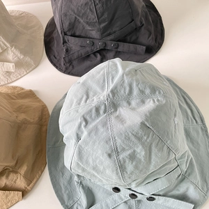 Flat lay of lightweight nylon sun hats in mint green, black, khaki, and cream colors