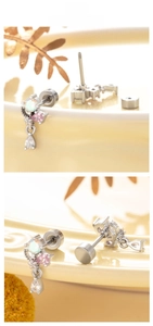 Détail de boucles d'oreilles pendantes argentées avec zircons colorés et fermoir plat