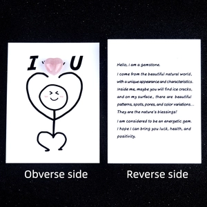 Natural rose quartz heart stone with a creative healing greeting card on black background
