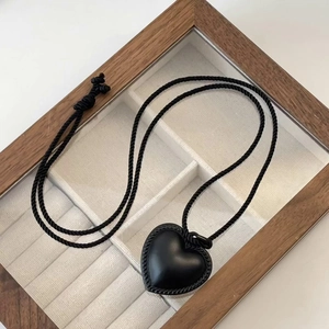 Collier élégant avec pendentif en cuir et cœur dans un coffret à bijoux en bois naturel