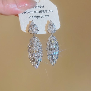 Close-up of sparkling hollow flower tassel earrings with zircons and 925 silver needle