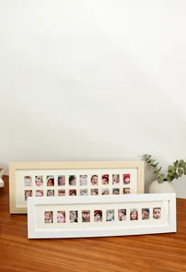 Detailed view of multi-aperture wooden child growth photo frames for record collection