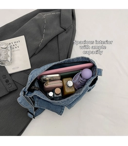 Top view of blue denim crossbody bag interior showing spacious storage for tablet and daily items