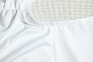 Detailed macro view showing the high-density stitching and white knit fabric of the dress