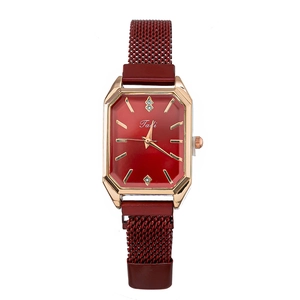 Close-up of red rectangular dial and magnetic Milanese strap on a rose gold quartz watch