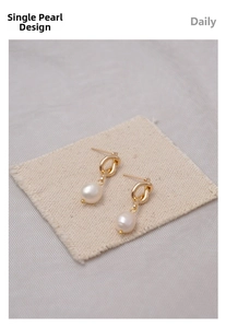 Close-up of elegant French vintage gold knot earrings with white freshwater pearls