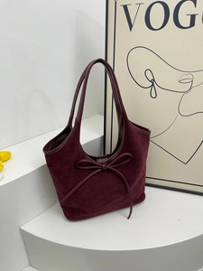 Retro burgundy frosted leather tote bag with a bow detail on a minimalist white background
