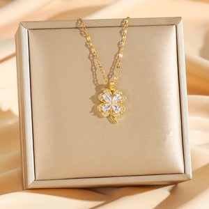 Gold clover necklace with white cubic zirconia on a jewelry box and silk background