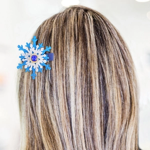 Sparkling blue snowflake hair clip with rhinestones and center blue gem worn by model