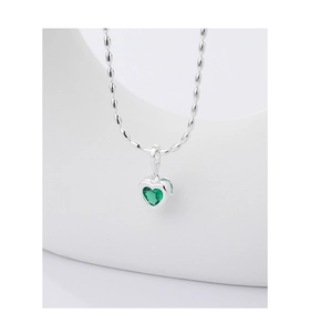 Close-up of heart-shaped green emerald pendant with silver-tone beaded chain