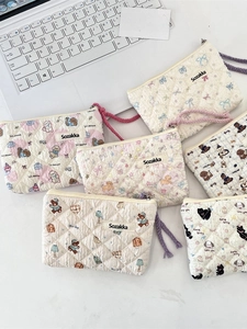 Quilted floral mini pouch set with cute animal prints and woven strap handles on marble