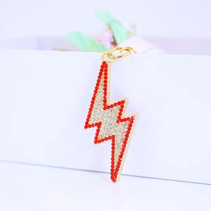Golden lightning bolt keychain with red and white rhinestones on a minimalist white gift box