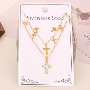 Close-up of gold stainless steel double layer necklace with cross pendants in a gift box