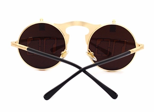 Detail view of round steampunk sunglasses with gold metal frame and flip-up lenses