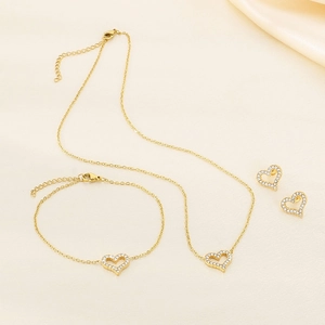 Detailed view of gold jewelry set with heart-shaped pendants and sparkling rhinestones